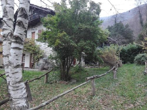 a wooden fence in front of a house with a tree at La Mianda in Ceres