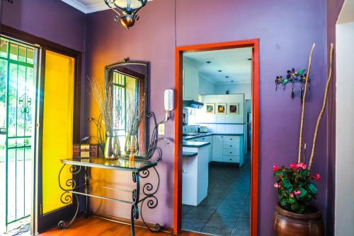 a kitchen with purple and yellow walls and a table at The Exclusive Guesthouse in Kempton Park