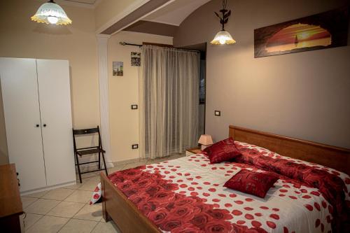 um quarto com uma cama grande e almofadas vermelhas em Casa Vacanze Etna em Linguaglossa