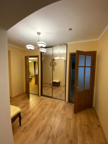 an empty living room with a mirror and a couch at Spadok in Kamianets-Podilskyi
