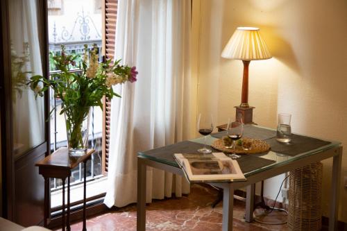 塞維利亞的住宿－Ispal Apartment & Parking Seville Historic Center vutse06601，一张桌子,上面放有酒杯和一盏灯,靠窗