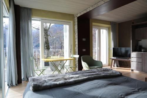 sypialnia z dużym łóżkiem i dużym oknem w obiekcie Tulipa Natural Home w mieście Mezzolago