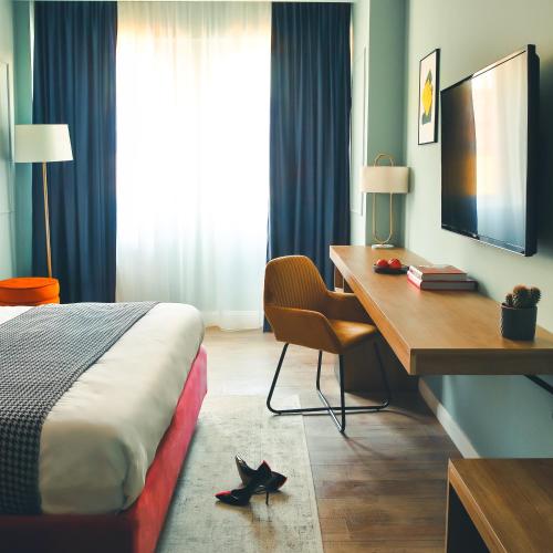 a hotel room with a desk and a bed and a desk and a monitor at JN Boutique Hotel in Bucharest