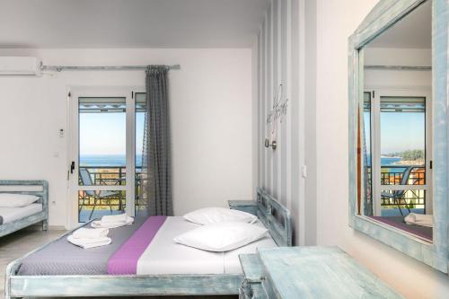 a bedroom with a bed and a view of the ocean at Studios Tasos in Chrysi Ammoudia