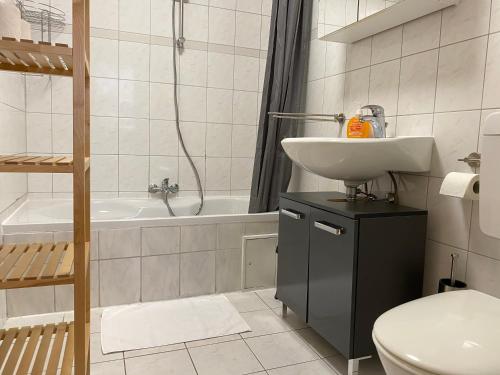 a bathroom with a sink and a toilet and a tub at SAD141 - Helle Monteurwohnung mit Balkon in Schwandorf in Schwandorf in Bayern