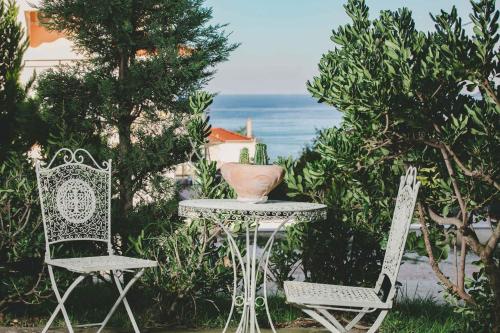 a table and two chairs and a vase on a table at Studios Tasos in Chrysi Ammoudia