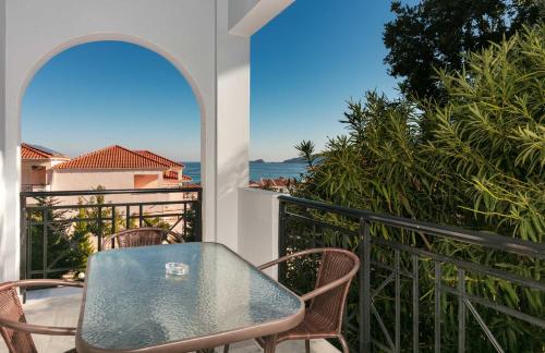 a table and chairs on a balcony with the ocean at Studios Tasos in Chrysi Ammoudia
