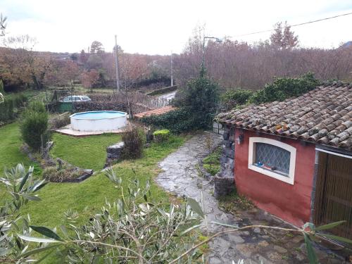a garden with a small red house and a tub at Villa Vecchio in Castiglione di Sicilia