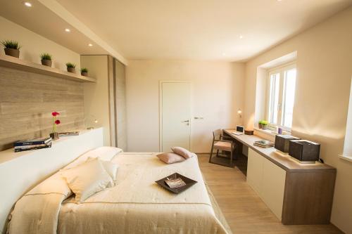 a bedroom with a bed and a desk in it at Fonte al Vento in Cortona