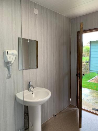 a bathroom with a sink and a mirror on the wall at Glamping at Holly Grove Farm in Stoke on Trent