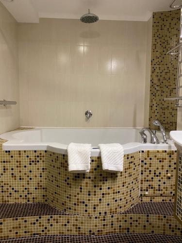 a bathroom with a tub with two towels on it at Spadok in Kamianets-Podilskyi