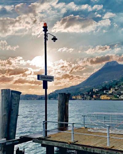 a street light on a dock on a body of water at Hotel Garnì Bartabel in Gargnano