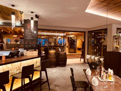 a restaurant with a bar and tables and chairs at Hotel CENTRAL Bar & Restaurant in Gerlos
