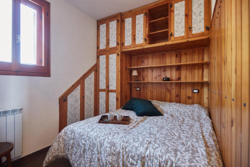 a bedroom with a bed with a wooden wall at Chiar di Luna Apartment in Roccaraso
