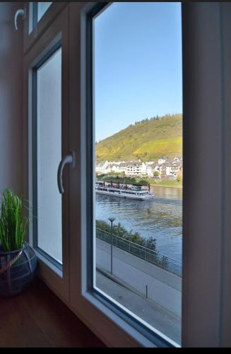 a window with a view of a boat in the water at Ferienhaus Maja in Cochem