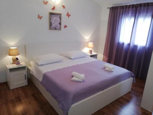 a bedroom with a bed with two towels on it at Apartment Pečarević - a holiday with a stunning view in Vis