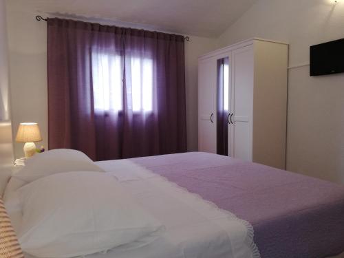 a bedroom with a large bed and a window at Apartment Pečarević - a holiday with a stunning view in Vis