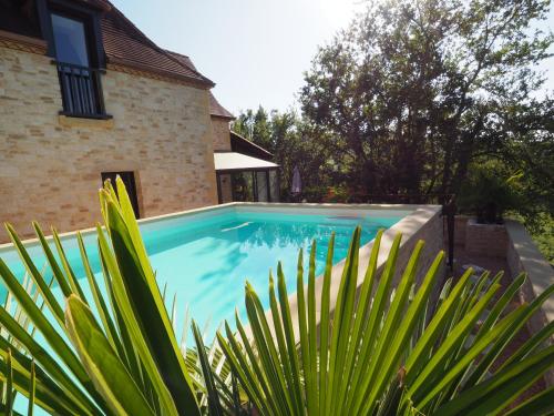 a swimming pool in front of a house at Magnifique Villa de prestige, piscine chauffée in Marnac