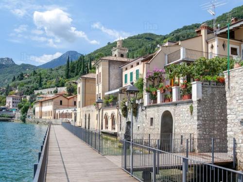 a bridge over a body of water with buildings at Hotel Garnì Bartabel in Gargnano