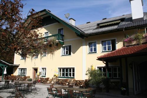 ein Gebäude mit Tischen und Stühlen im Innenhof in der Unterkunft Gasthaus Überfuhr in Elsbethen