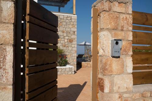 a wooden door with a mailbox next to a brick wall at Villa Alkyoni Lindos in Líndos