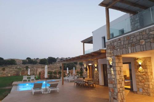a house with a patio and a swimming pool at Villa Alkyoni Lindos in Líndos
