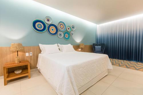 a bedroom with a white bed and a blue wall at Manati in Barra Grande