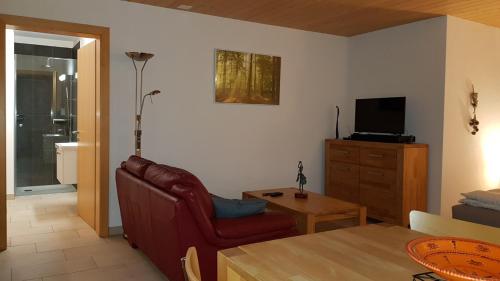 a living room with a couch and a chair and a television at Studio dans une villa à Veyras in Veyras