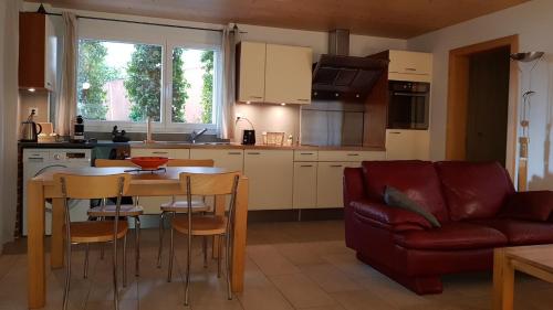 a kitchen and living room with a table and a couch at Studio dans une villa à Veyras in Veyras