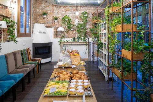 una habitación con una mesa con comida y plantas en Maxxim Hotel en Ferrara