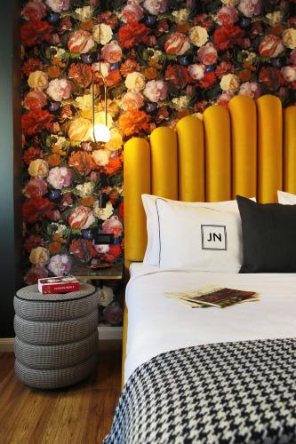 a bedroom with a bed and a floral wall at JN Boutique Hotel in Bucharest