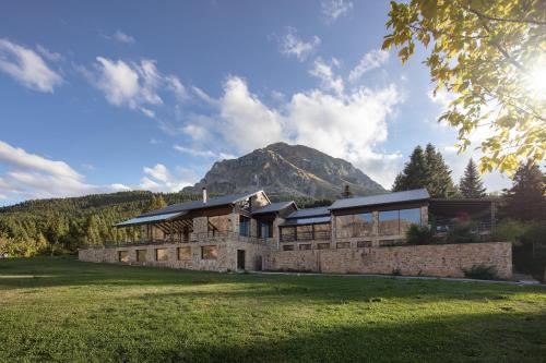 a stone building with a mountain in the background at Orizontes Tzoumerkon Hotel Resort in Pramanta