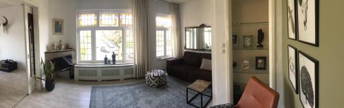 a living room with a couch and a window at Tastefull double story 2 bedroom appartment/house in Haarlem