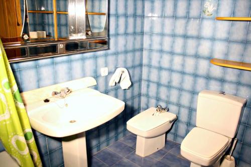Casa Toni في هورتا دي سان خوان: حمام من البلاط الأزرق مع حوض ومرحاض