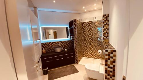 ein Badezimmer mit einem Waschbecken, einem WC und einem Spiegel in der Unterkunft the Lodge in Bad Sobernheim