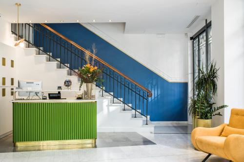 a lobby with a green counter and stairs at Bahar Boutique Hotel in Thessaloniki
