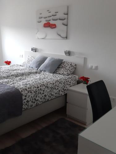 a bedroom with a bed with red shoes on the wall at Szalók Spa Apartman Egerszalók in Egerszalók