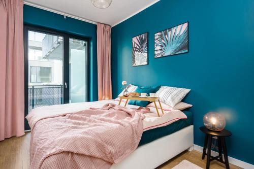sypialnia z niebieskimi ścianami i łóżkiem ze stołem w obiekcie Apartament Małe Garbary w Poznaniu