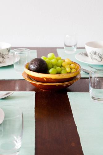 a bowl of fruit on a table with plates and glasses at Shortstay Scheveningen in Scheveningen