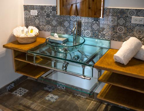 a bathroom with a glass sink and a counter at OJO AZUL RESORT in Valle de Guadalupe