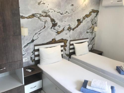 two beds in a room with a wall at CASA NEPTUN in OLD BATUMI in Batumi
