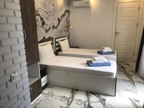 two beds in a small room with a door at CASA NEPTUN in OLD BATUMI in Batumi
