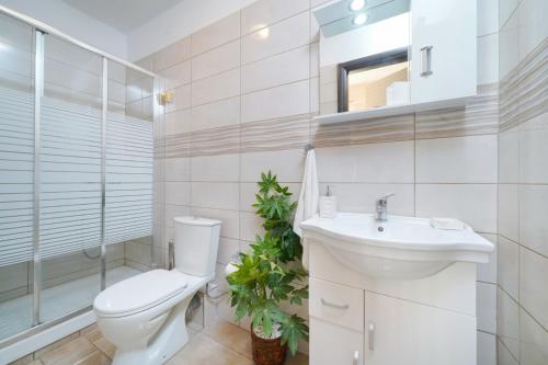 a white bathroom with a toilet and a sink at Villa Irene in Skala Marion
