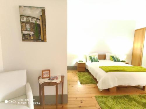 a bedroom with a bed with a green blanket at Alojamento Local F&B in Guimarães