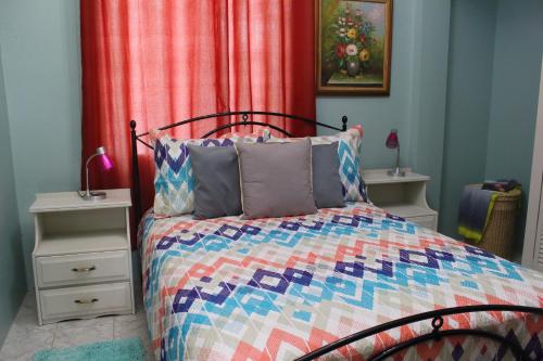 sypialnia z łóżkiem z kolorową kołdrą w obiekcie The AnSwin Apartment w mieście Roseau