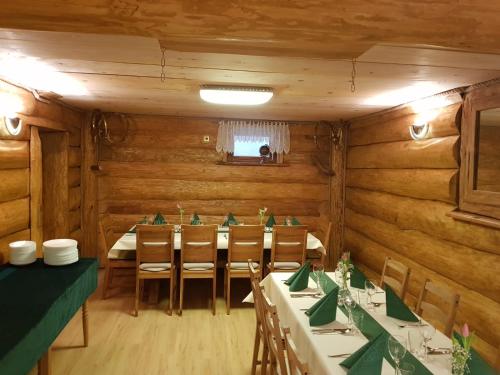 ein Esszimmer mit Holzwänden, Tischen und Stühlen in der Unterkunft Happy Big Family in Oberried