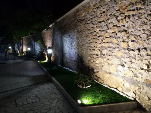 a stone wall with a bench in front of a building at Altavilla Holiday House in Tivoli