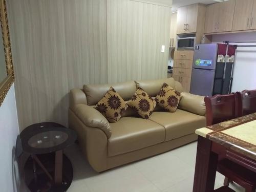 uma sala de estar com um sofá com almofadas em Jones Shore Residences em Manila