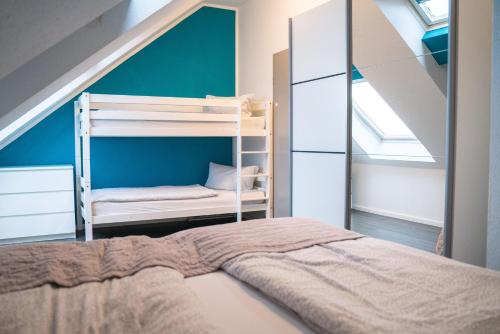 1 dormitorio con litera y pared azul en Apartments Andante, en Rust