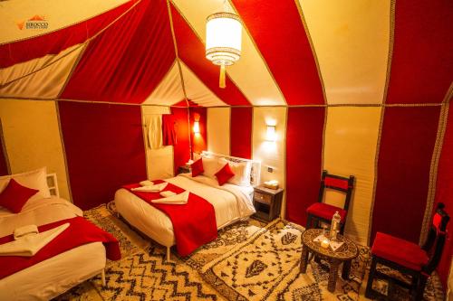 a room with two beds in a circus tent at Sirocco Luxury Camp in Merzouga